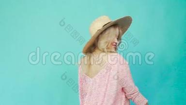 一个女孩戴着草帽和一件夏天的连衣裙转过来，展示一件连衣裙。